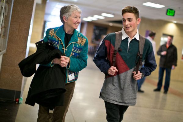 Older woman CAP volunteer walks down the hall with teenage mentee.